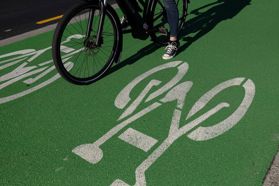 White,Cycle,Illustation,On,Cycleway,Woman,Stopped,On,E-Bike,With,One,Foot,On,Ground.